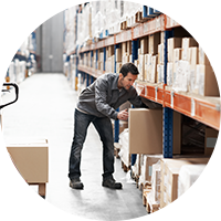 Man in warehouse putting up boxes keeping ergonomically friendly