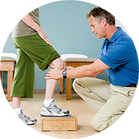 Therapist evaluating a patients knee while they stand on a block