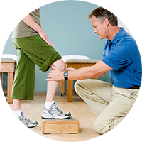 Therapist evaluating a patients knee while they stand on a block
