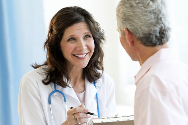 Woman Doctor Smiling At Patient