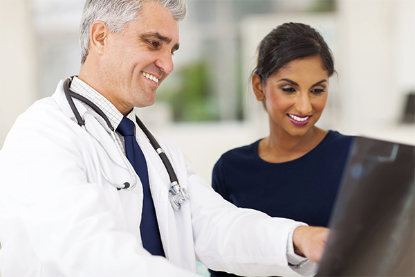 Specialized Benefits For Patients Doctor and Patient Smiling at Screen