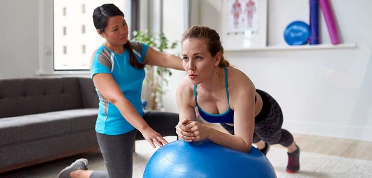 Female athletic trainer training a patient for core stability.