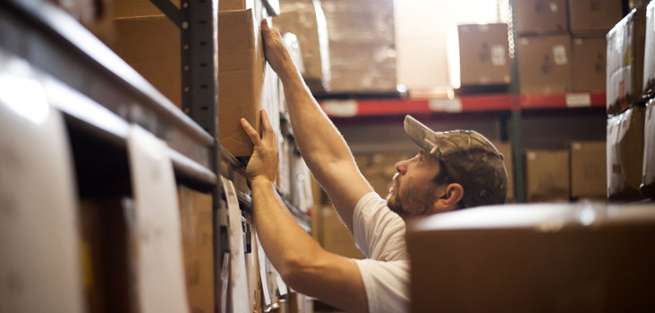 Man working in warehouse stacking boxes