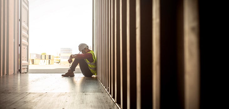 Construction worker sitting in a dim area