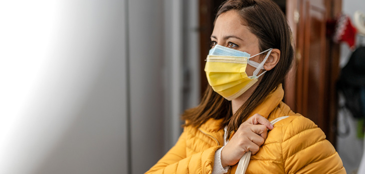 Female employee with a jacket wearing a mask at work