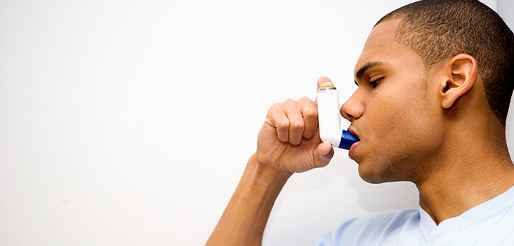 Man using an inhaler for occupational asthma