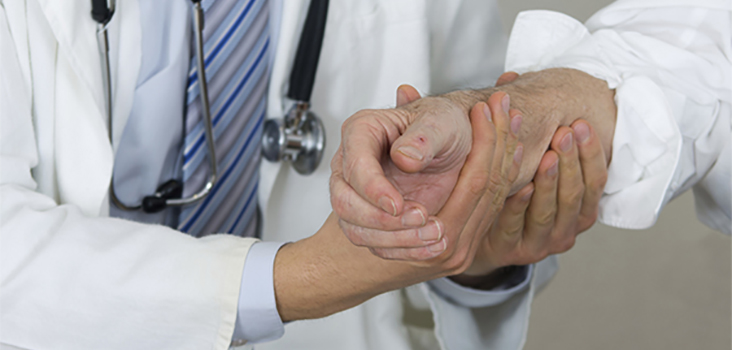 Physician checks out older man's wrist and arm