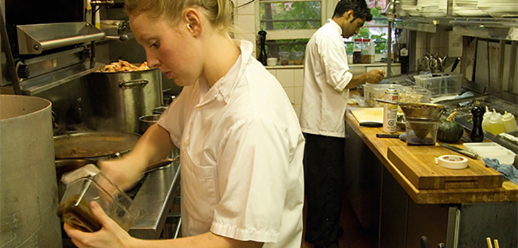 Female and male chefs cooking in kitchen