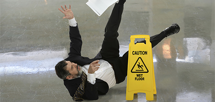 Man in professional attire slipping and falling on wet floor
