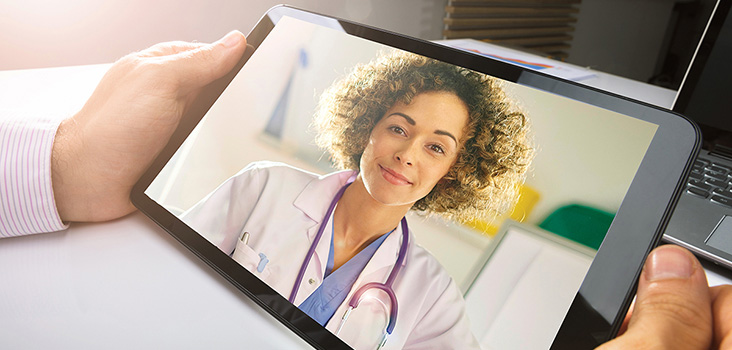 Man videochats with physician on tablet