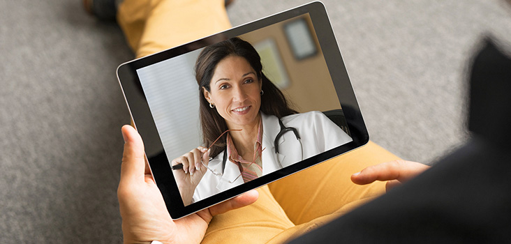 Woman videochatting with physician through tablet