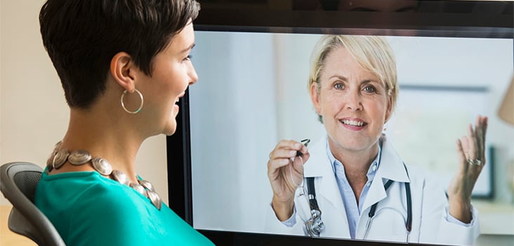 Woman videochatting with physician through television