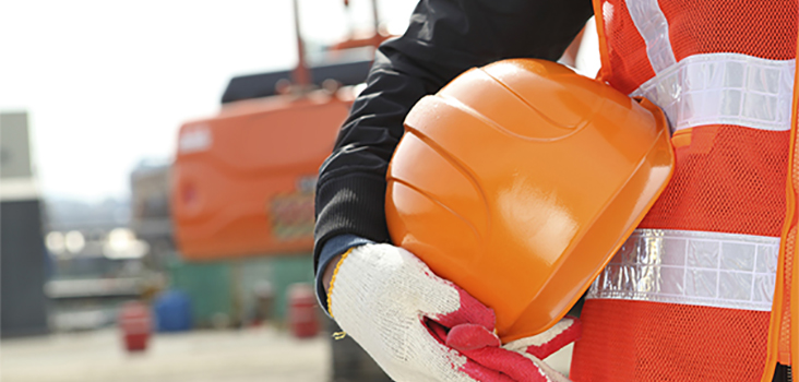 Construction worker holding an orange hard hat