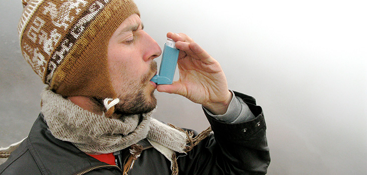 Man in the cold using an inhaler for asthma